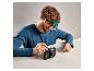 Man repareert camera met vergrootbril en gereedschap.