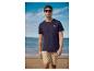 Man in een marineblauw T-shirt en beige korte broek op het strand.