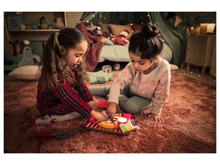 Twee meisjes spelen met een nep-pizza en een pizzames.