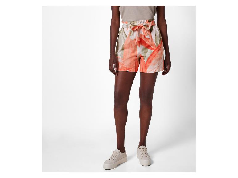 Hoge taille shorts met bloemenprint en sneakers.