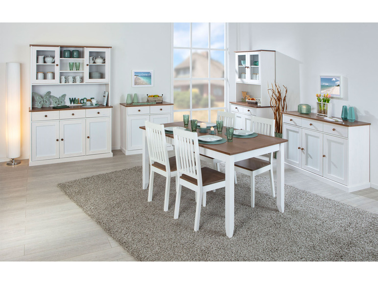 Een eettafel met stoelen en witte dressoirs met glasdeuren.