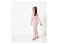 Een meisje draagt een roze pyjama met hartjesprint
