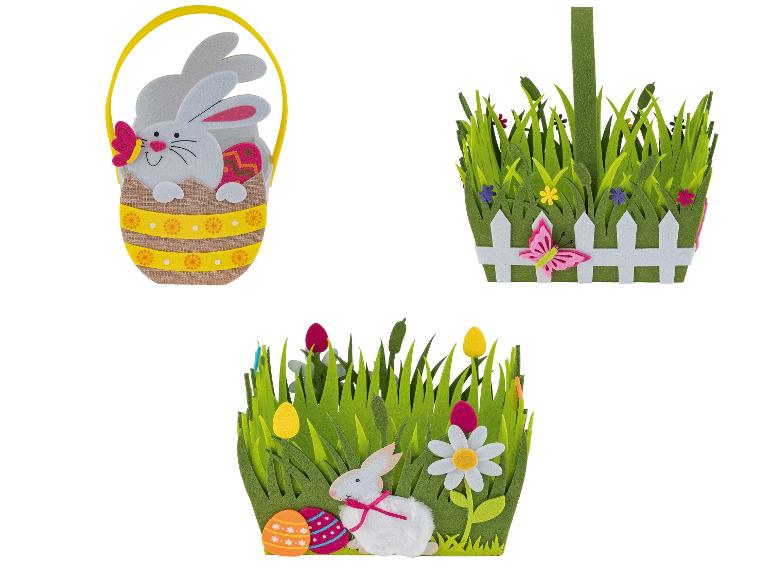 Drie paasmandjes met konijnen, eieren en gras.