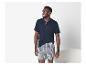 Man in donkerblauw Henley-shirt met korte mouwen en geruite boxershorts.