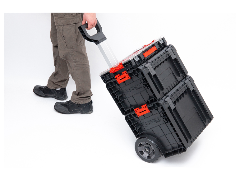 Een persoon trekt een Sortimo gereedschapskar met twee stapelbare dozen.