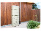 Beige regenwatertank tegen houten wand.