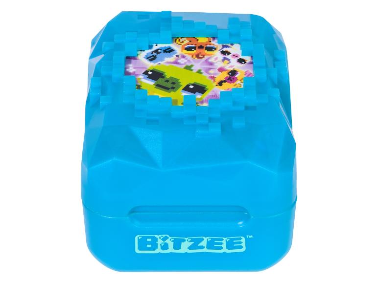 Blauw Bitzee-speelgoed met gepixelde wezens op het scherm.