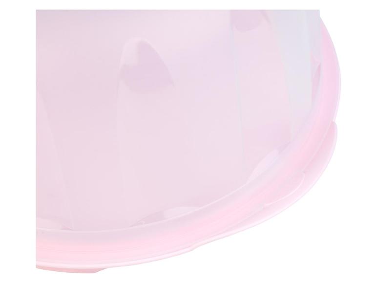 Een roze plastic cakebeschermer met een doorzichtige deksel.