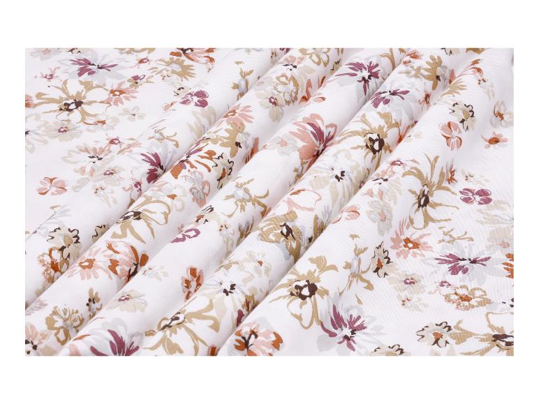 Witte stof met bloemenpatroon in bruine, roze en paarse tinten.