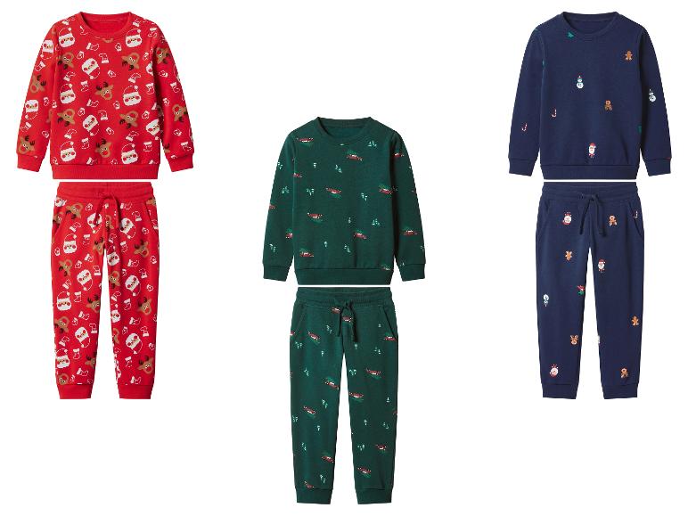 Drie kinderkerstpyjamasets met feestelijke prints, in rood, groen en marineblauw.