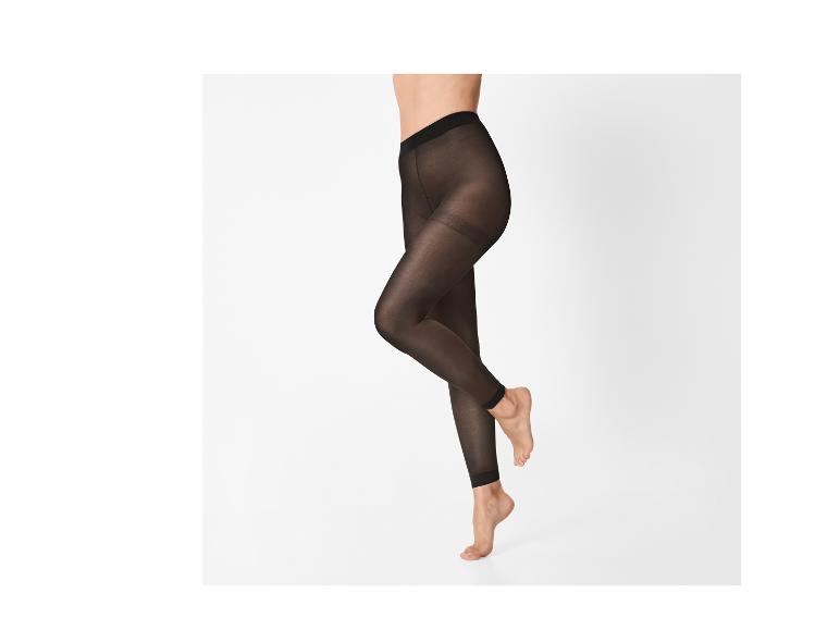 Vrouw in doorschijnende zwarte high-waist legging, poserend op haar tenen.