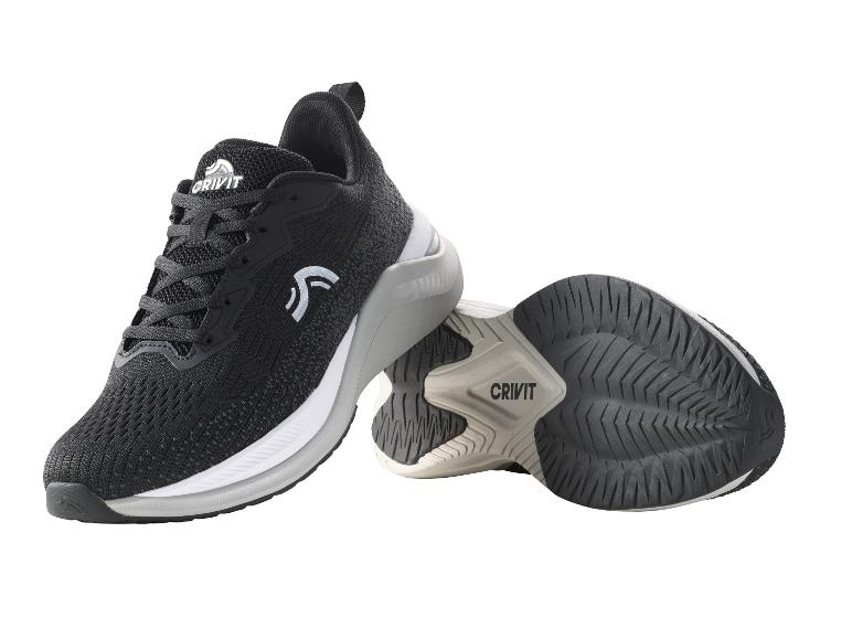 Zwarte sportschoenen met wit-grijze zool, naast elkaar liggend.