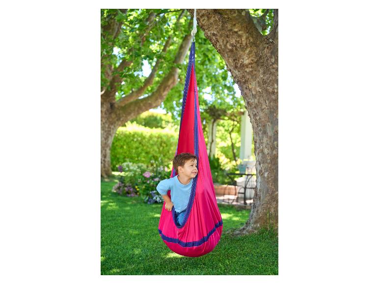 Kind in een rode hangmat-schommel in de tuin.