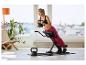 Vrouw traint op een buikspiertrainer met een 6 kg kettlebell, een 8 kg kettlebell op de grond.