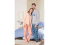 Een stel in bijpassende pyjama's, hij draagt een grijze top met 'Brooklyn' print en blauwe geruite broek, zij draagt een roze top en een broek met bloemenprint.