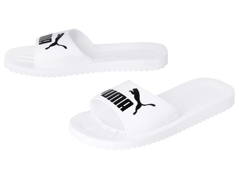 Witte Puma slippers met zwart logo, getoond in twee hoeken.