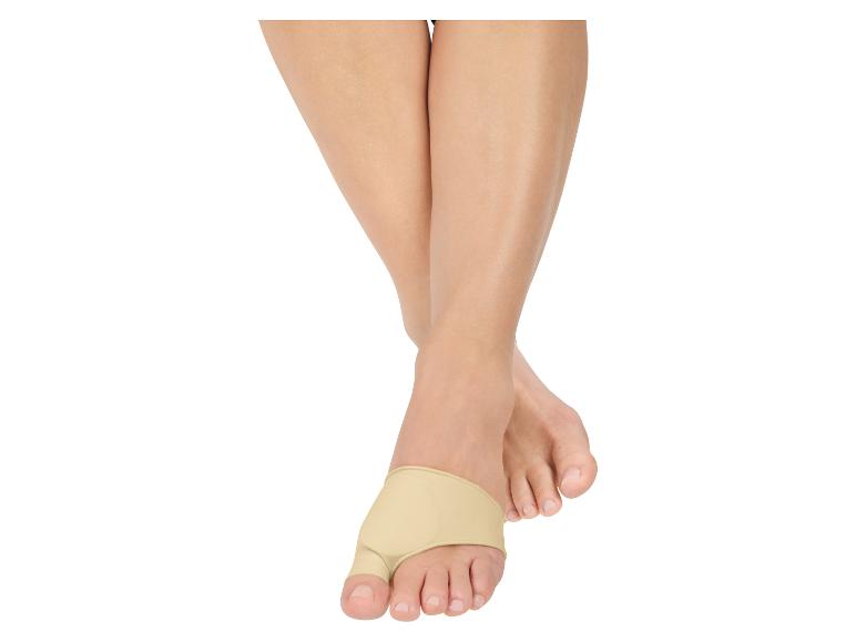 Beige teenspreider op een vrouwenvoet.