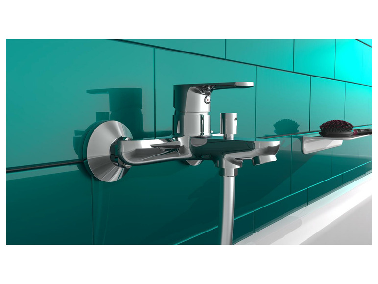 Een chromen badkamerkraan op een turquoise betegelde muur.
