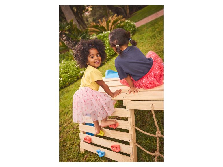 Twee meisjes spelen op een houten klimrek in de tuin.
