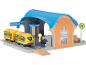 Speelgoedtreinstation met trein, conducteur en informatieborden.