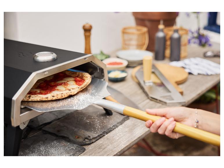 Pizza uit een pizzaoven halen met een pizzaschep.