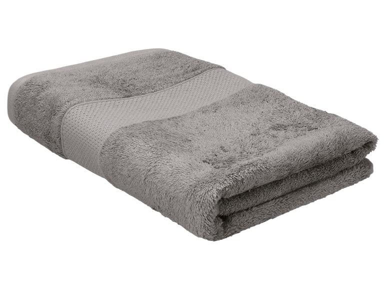 Gevouwen grijze handdoek met een getextureerde band, geïsoleerd op een witte achtergrond.