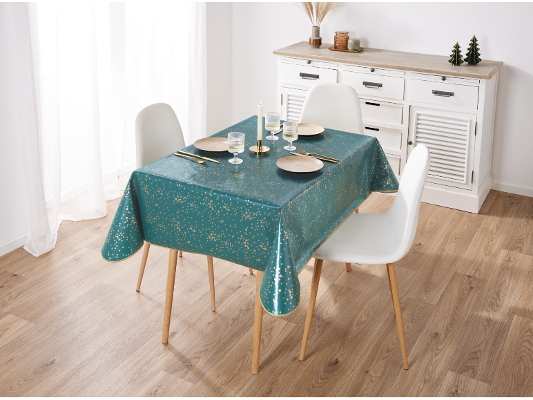 Eettafel met teal tafelkleed met gouden sterren, borden en bestek.