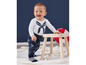 Baby in een wit shirt met marineblauwe strepen en een blauwe broek met bootjes print.