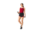 Een vrouw in een rood tanktop en zwarte shorts traint met dumbbells.