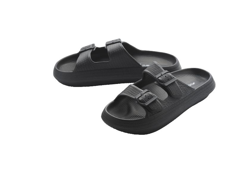 Een paar zwarte sandalen met twee bandjes en gespen.