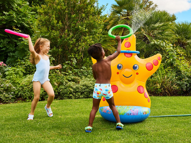 Twee kinderen spelen met een opblaasbaar zeester-spuitwater-speelgoed in de tuin.