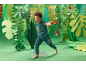 Kind speelt in een groene jungle-omgeving, gekleed in een Paw Patrol-outfit.
