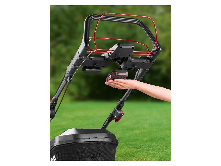 Hand plaatst een accu in een Parkside accugrasmaaier.