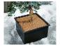 Kunstplant in zwarte pot, omringd door decoratieve sneeuw.
