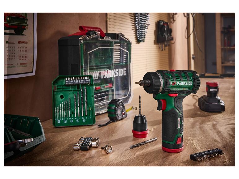 PARKSIDE 12 V accuboormachine met accu, oplader en accessoires op een houten werkbank.