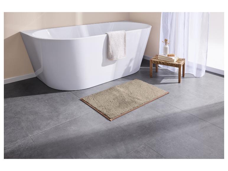 Grijs badmat voor een wit bad.