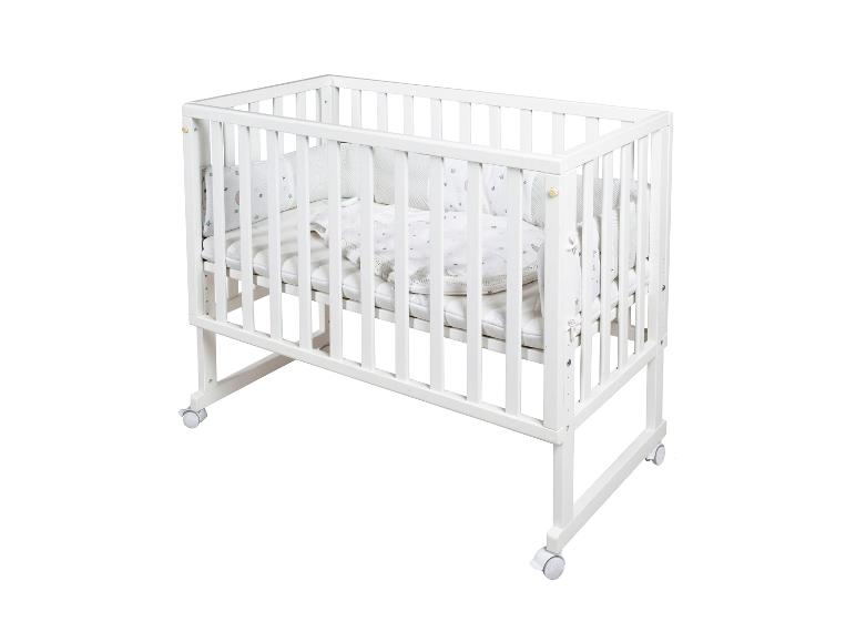 Wit babybedje met beddengoed met sterren- en maanpatroon