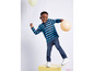 Een jongen in een gestreepte trui en jeans speelt met ballonnen.