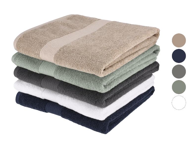 Stapel zachte handdoeken in verschillende kleuren.