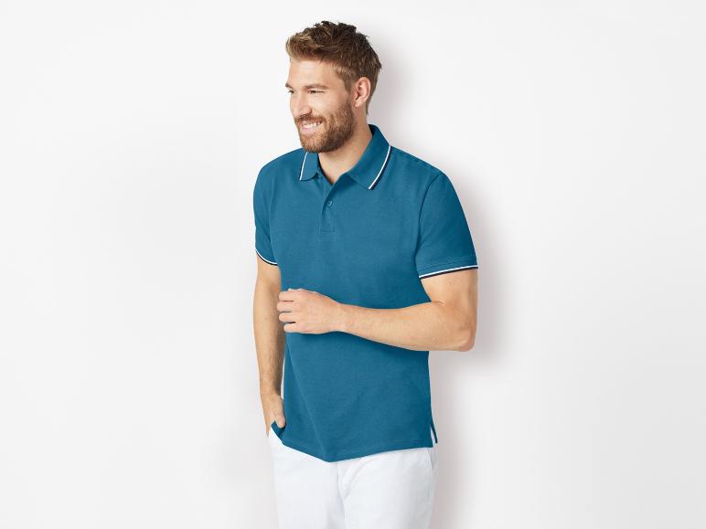 Donkerblauw heren polo shirt met contrasterende kraag en witte broek.