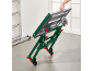 Opvouwbare werkstandaard met wielen, vastgehouden door een hand, met een ladder op de achtergrond.