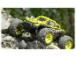 Een gele en zwarte Extron monstertruck rijdt over rotsen.