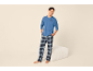 Lachende man in blauwe pyjama en geruite broek, met het motief 'Coffee is my therapy'.
