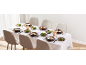 Eettafel gedekt met soepkommen, saladeborden en glazen voor zes personen.