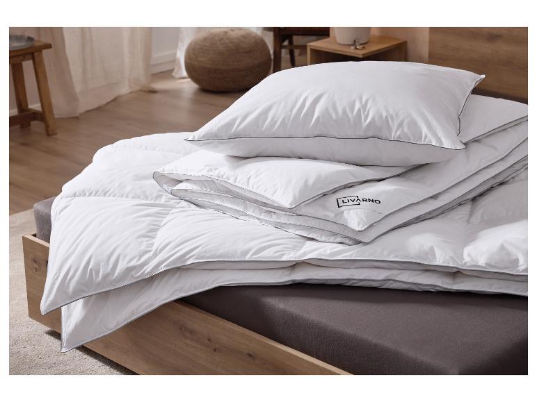 Wit kussen en dekbed met grijze randen op een houten bed.