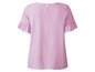 Een lichtroze blouse met korte mouwen en ruches.