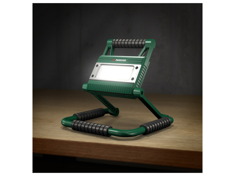 Een groene Parkside werklamp met een verstelbare voet.
