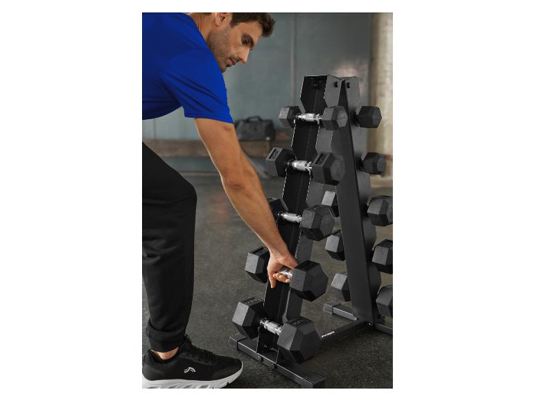 Man pakt een halter van een halterrek in de sportschool.