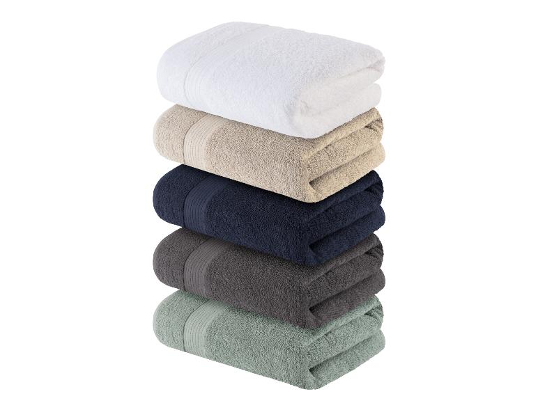 Stapel badhanddoeken: wit, beige, donkerblauw, grijs en groen.