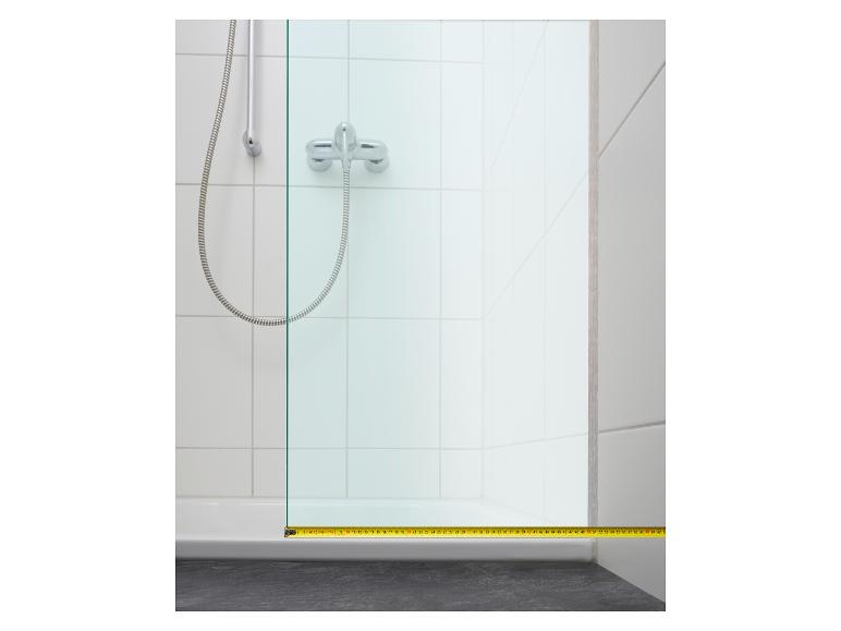 Een douchecabine opmeten met een meetlint.